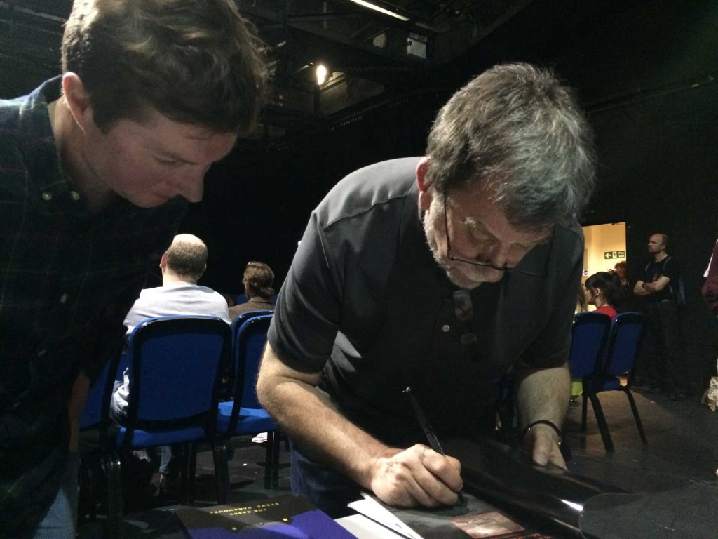 Steve Parkhouse signs some of his work for a fan at EdenCon 2015.