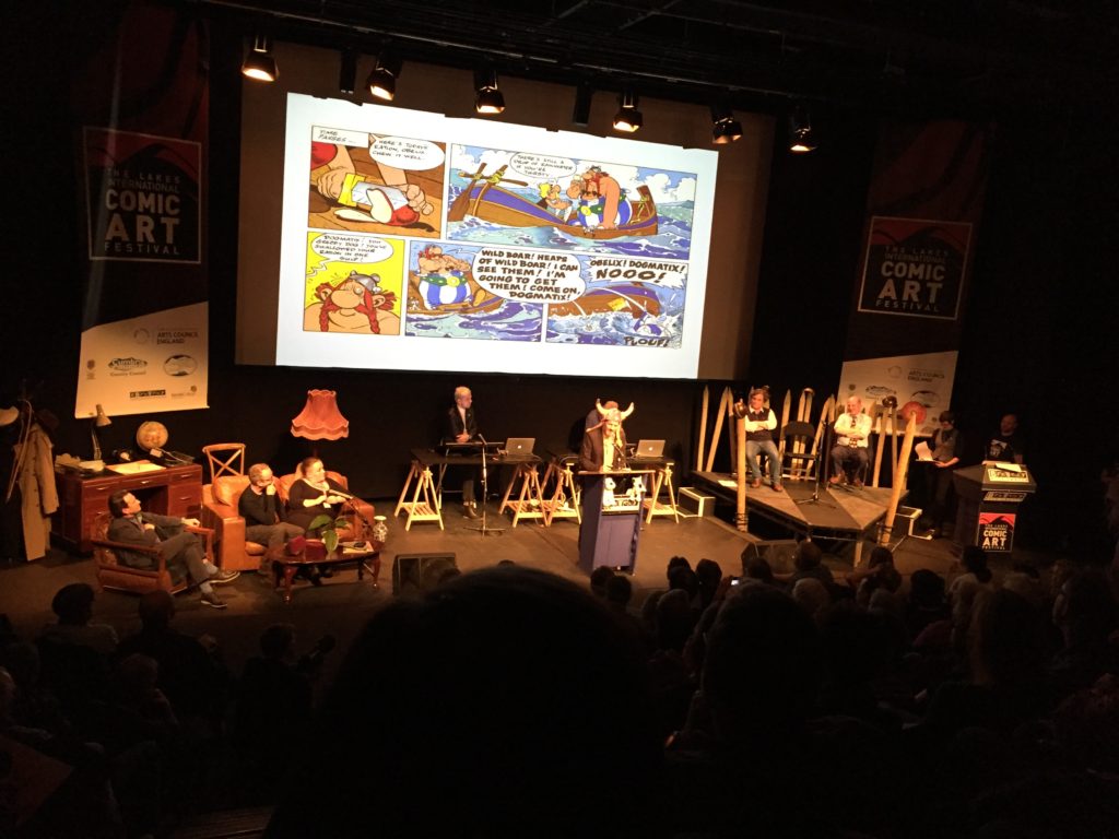 Artist Charlie Adlard attempts to convince the audience Asterix is better than Tintin by wearing a silly hat and kicking Snowy! (It's a puppet...)