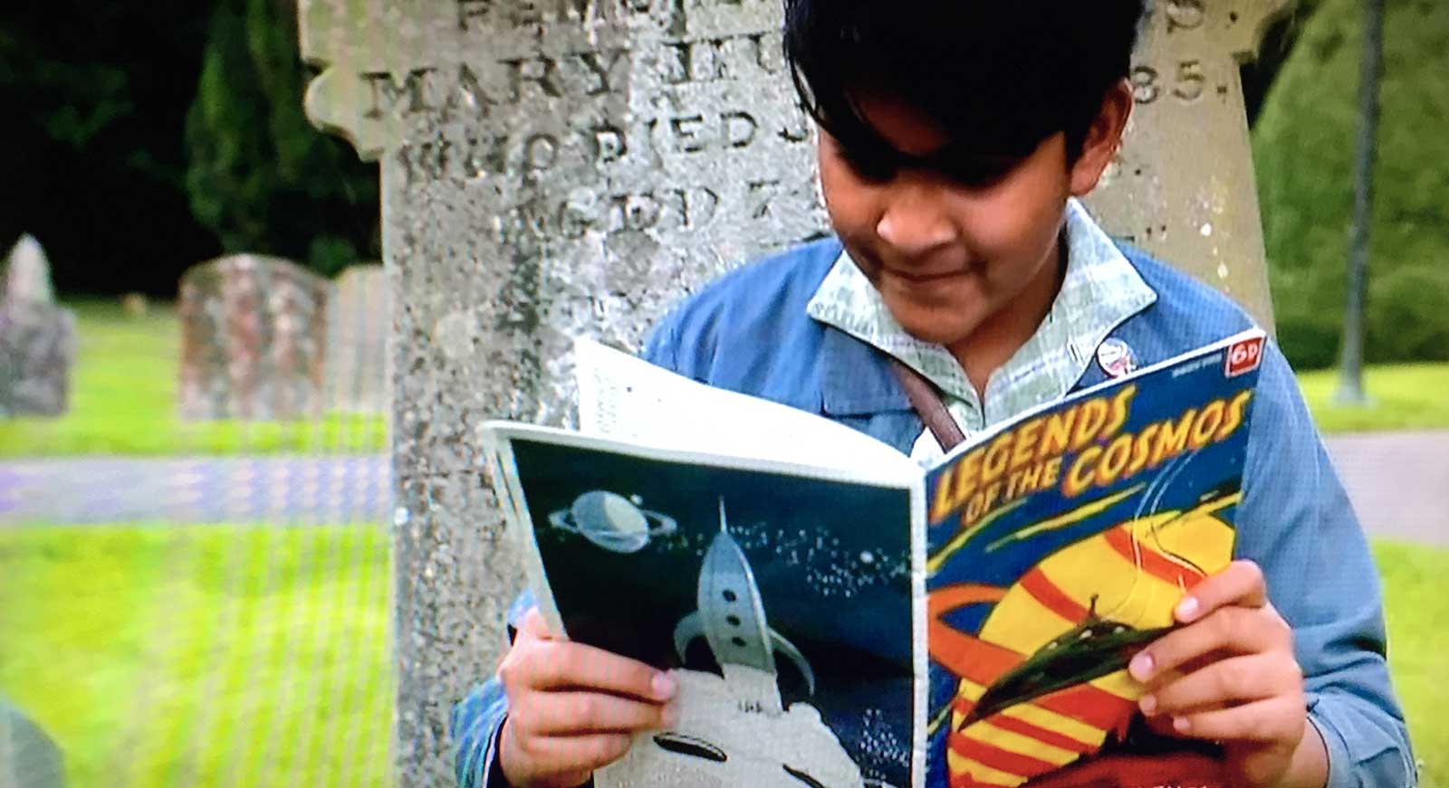 Nikhil Prasad (Yadav Ganatra) reads Legends of the Cosmos in the Father Brown episode "Fire in the Sky"