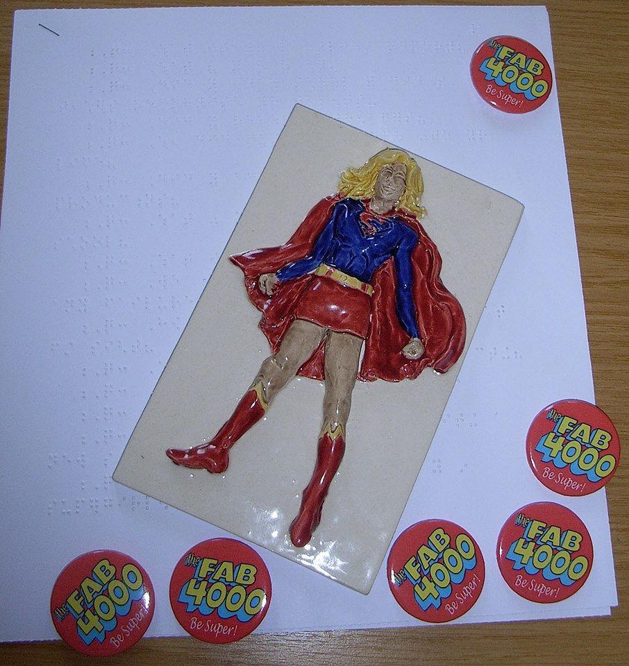 A ceramic Supergirl across a page of braille. This was created by the children of St Vincent's School for the Blind in Liverpool as a gift for Supergirl actress Chyler Leigh on her visit to the school this week. Photo courtesy Tim Quinn