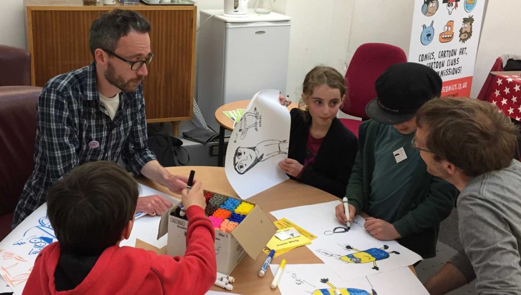 Ace artist Marc Jackson is taught how to draw properly by Lancaster's budding comic creators! Photo: John Freeman