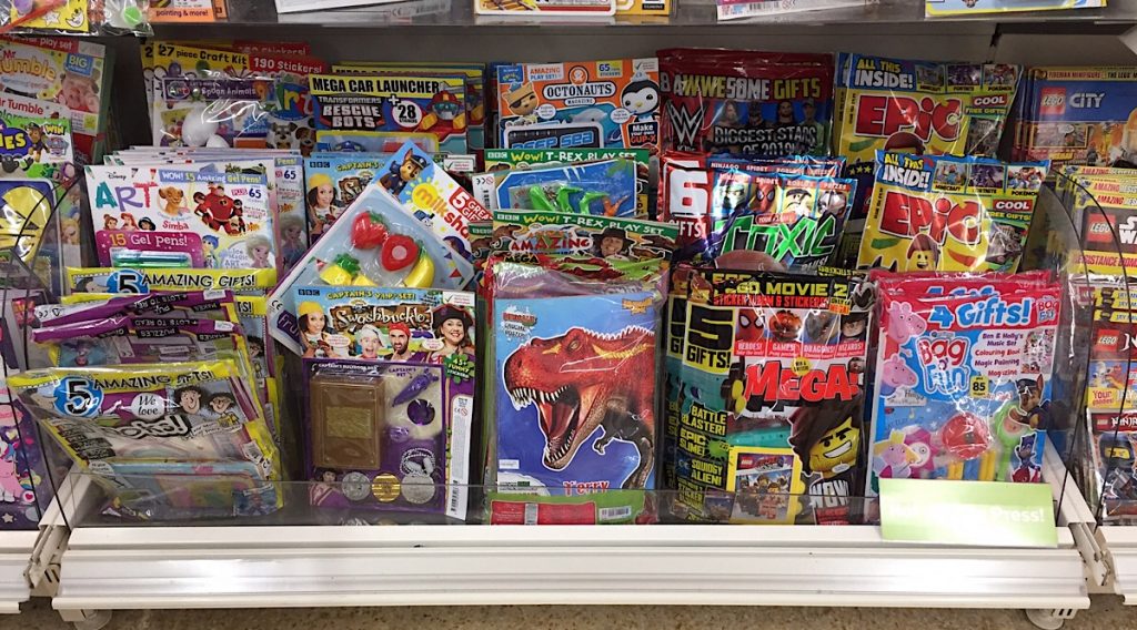 Some of the many titles aimed at younger readers. on sale in Sainsbury’s, Lancaster in February 2019. Most come bagged with a toy as an incentive, but parents seem increasingly uncomfortable at the amount of plastic included 