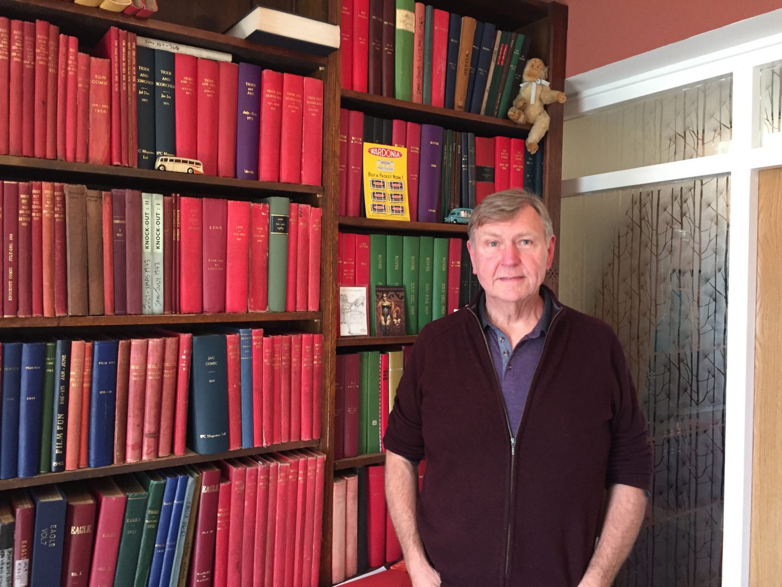Comic collector Peter Hansen. Behind him, just some of the bound editions of comics assembled for internal use by various British comic companies such as Amalgamated Press and IPC