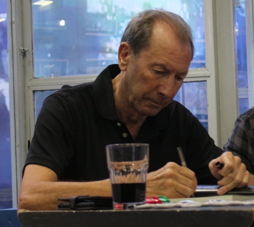 See this guy? Look. See the concentration... the focus... the dedication to service etched into every line... That's V for Vendetta artist David Lloyd at a recent signing, not only enjoying the privilege of meeting nice people but also selling volumes of Aces Weekly via the coded access cards the team produce that all come with a free 