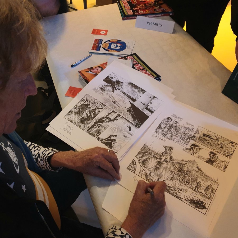 Pat Mills signing a set of the “Charley’s War” portfolio prints. Photo: Pat Mills