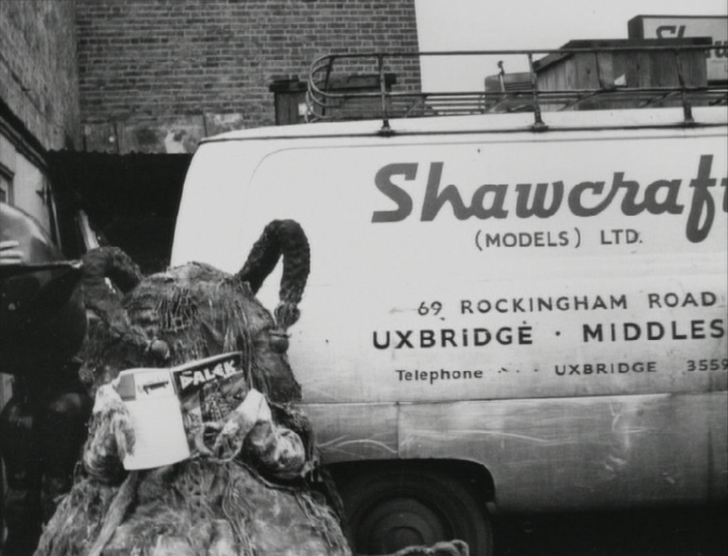 A Dalek fan reading a Dalek annual beside a Shawcraft Models van in the 1960s