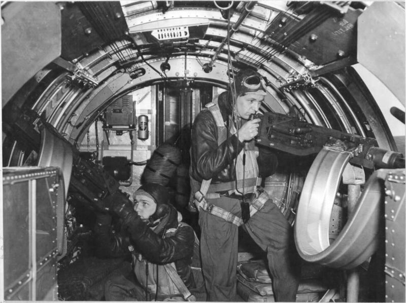 Boeing B-17F-30-BO Flying Fortress "Invasion 2nd" (42-5070) of the 8th Air Force, 91st Bombardment Group, 401st Bombardment Squadron. In the waist gunner positions are Staff Sergeant Eldon R. Lapp of Fort Wayne, Indiana and Staff Sergeant William D. King operating the Browning .50 caliber (12.7 mm) machine guns for a Signal Corps photographer