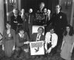 Fleetway staff at the launch of New Eagle in 1982 at the Waldorf Hotel, London, stage managed by Barrie Tomlinson. Top Row, left to right: Jack Cunningham (art staff), John Jackson (art staff), Doug Church (art editor), the Mekon, Roy Preston (writer), Sid Bicknell (Fleetway editor), then Barrie Tomlinson, standing. Bottom Row, left to right: Barrie's secretary, Debbie Watts; Paul Bensberg (art staff); David Hunt, holding the Eagle logo; Ian Rimmer (assistant editor); and Janet Dixon (sub editor). Photo courtesy Barrie Tomlinson