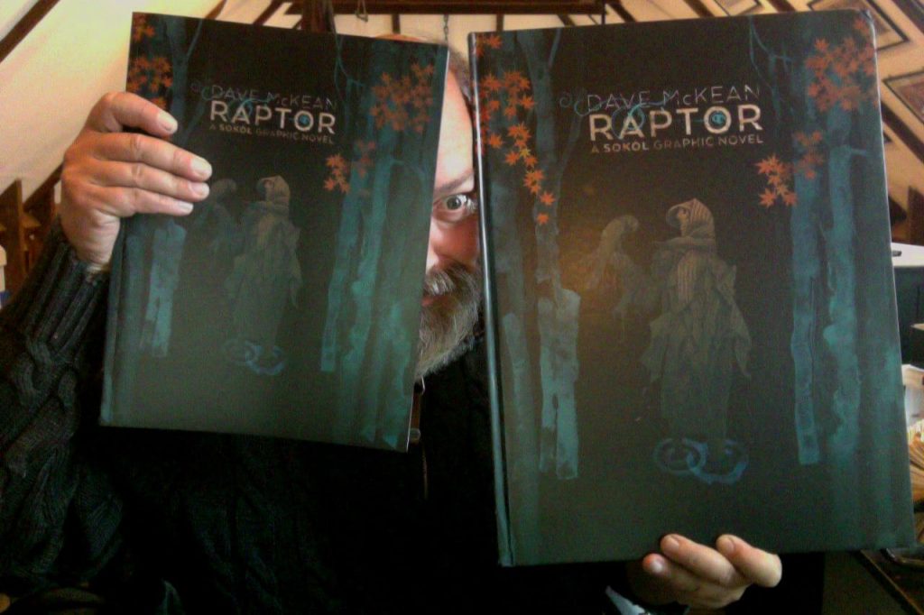 Dave McKean with copies of both the paperback and deluxe, oversized hardcover edition of Raptor