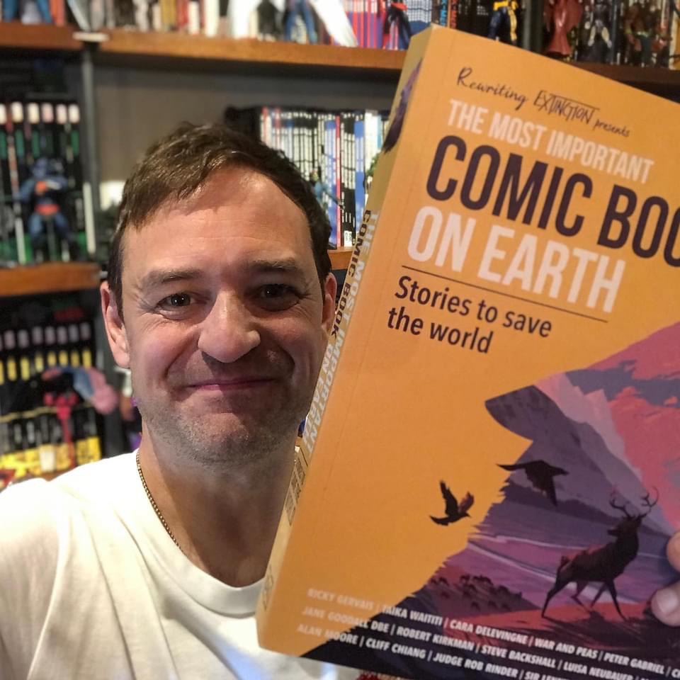 Paul Goodenough with a copy of the Rewriting Extinction comic anthology, The Most Important Comic Book in the World