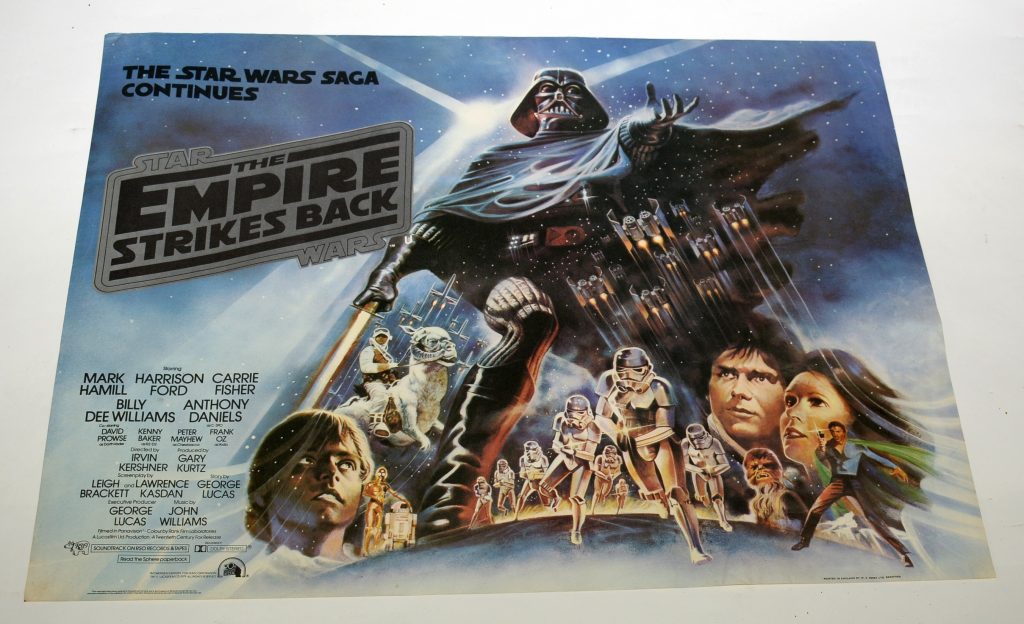 Star Wars The Empire Strikes Back British quad film poster, an original poster printed by W.E. Berry Ltd, Bradford 1980, black on silver logo, showing Darth Vader and other leading characters, 75 x 101cms