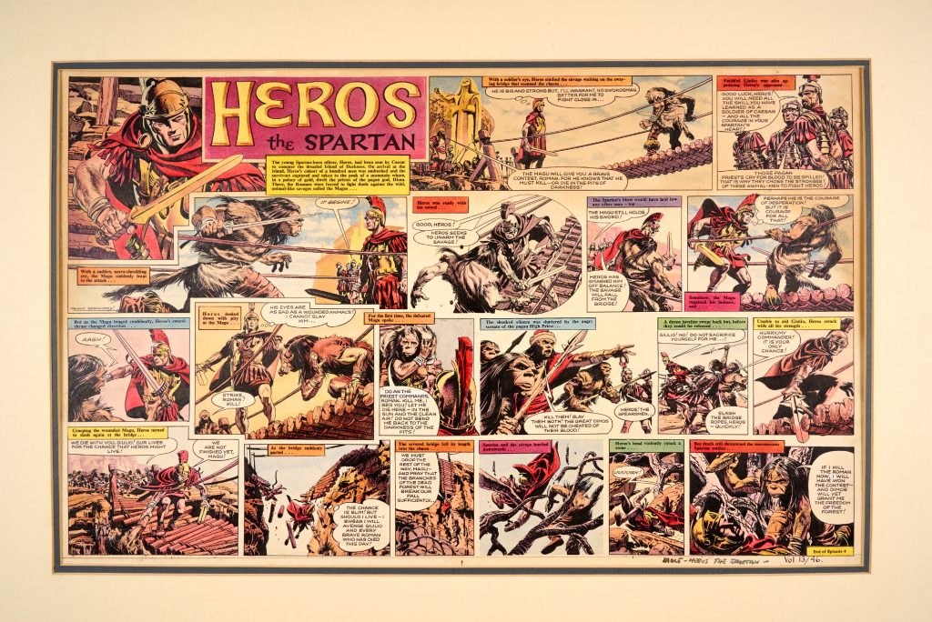 “Heros the Spartan” original double-page artwork (1962) painted and signed by Frank Bellamy, for The Eagle Vol. 13 No 46. Taken prisoner to the mountain Palace of Gold, inhabited by the priests of the pagan god, Diom, Heros and his cohort survivors are forced to fight duels against the wild, animal-like savages called the Magus... | Bright Pelikan inks on board, 28 x 20 ins. The Heros title lettering and rectangular text boxes are laser colour editions to complete the look of the artwork and may be removed if required
