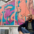 Mehdi Annassi alongside his Windermere Arctic Charr mural at the Lake District Boat Club for LICAF 2022