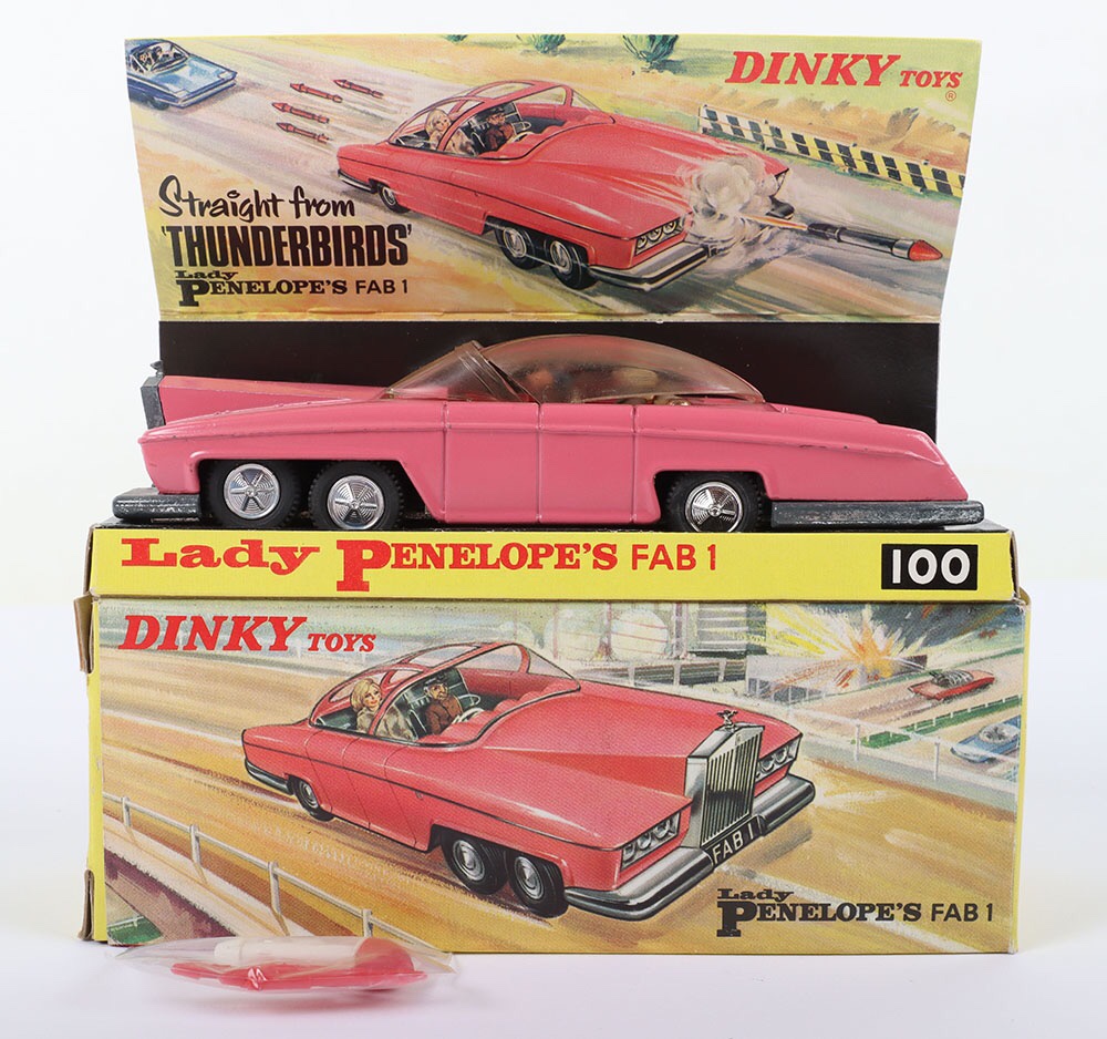 Dinky Toys Boxed 100 Lady Penelope’s FAB 1 From TV series ‘Thunderbirds’ pink body, early issue with pink flashes on plastic sliding roof, domed detailed wheel hubs, with Lady Penelope and Parker figures ‘FAB 1’ complete with paper number plate to front only and flying lady motif, in mint original condition, some tarnish to chrome plating (usual on this model) complete with four rear harpoons & one rocket. Original inner card display box is excellent, outer illustrated box is in excellent bright condition, small 15mm tear to one inner tab, still a very nice example of this popular model
