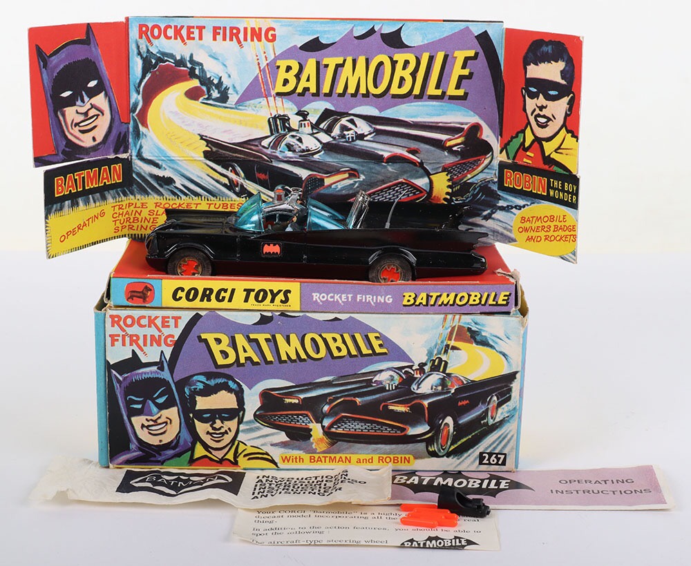 Boxed Corgi Toys 1st issue 267 Rocket Firing Batmobile with Batman and Robin, gloss black, red bat hubs, blue tinted windscreens, with original "Batman & Robin" figures, working pulsating exhaust flame, in very good to excellent original condition, including a good original inner illustrated card stand, with some age/edge wear, instruction envelope, instruction leaflet, 6 orange missiles, early features leaflet, plus black plastic hook attachment for Batboat. Missing cloth lapel badge, original outer blue and yellow carded picture box is in good original condition, complete with all end flaps, with some age/edge wear, 17/11 in pencil to one picture side.