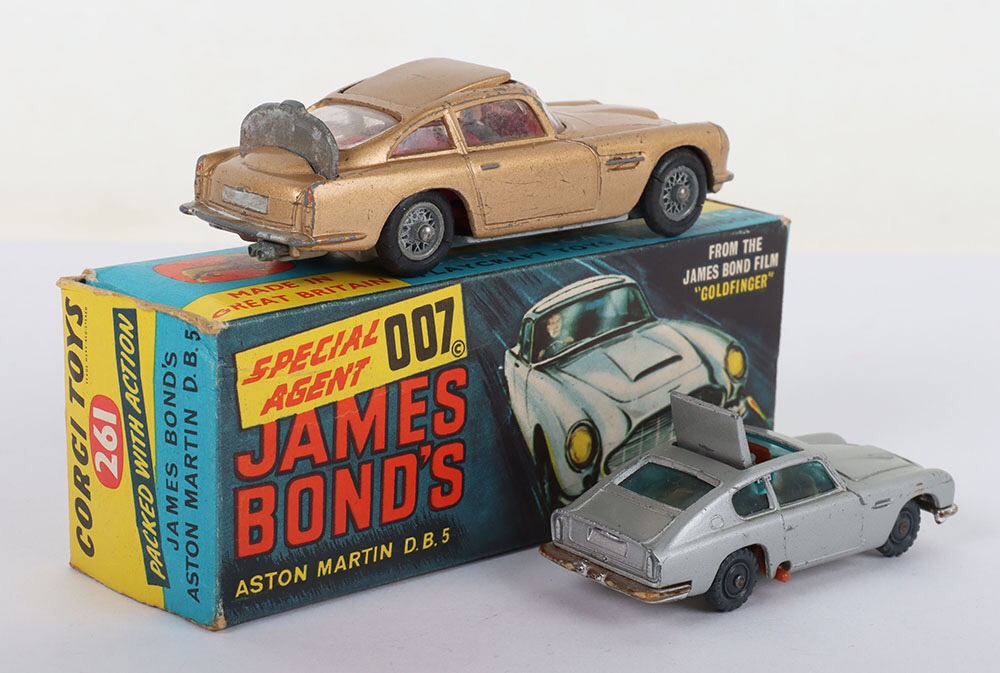 Corgi Toys 261 James Bond Aston Martin D.B.5 from the Film “Goldfinger” gold body, with ejector seat, rear bullet screen, retractable machine guns, model is in fair to good used original condition, with original outer illustrated box only, with end flaps in fair to good original condition, some edge/age wear and unboxed Husky James Bond Aston Martin D.B.5, with ejector seat, missing bandit figure.(3 items)