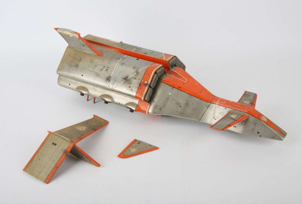 Terrahawks - Battlehawk replica model made by David Sissions in the 1980',  similar to those used in the production of Terrahawks, the 1980s British science fiction television series produced by Thunderbirds creator Gerry Anderson, in conjunction with Christopher Burr. It is constructed from fibreglass and features a silver and orange paint finish with detailed panel lines and weathering, approx. 52 cm long.
