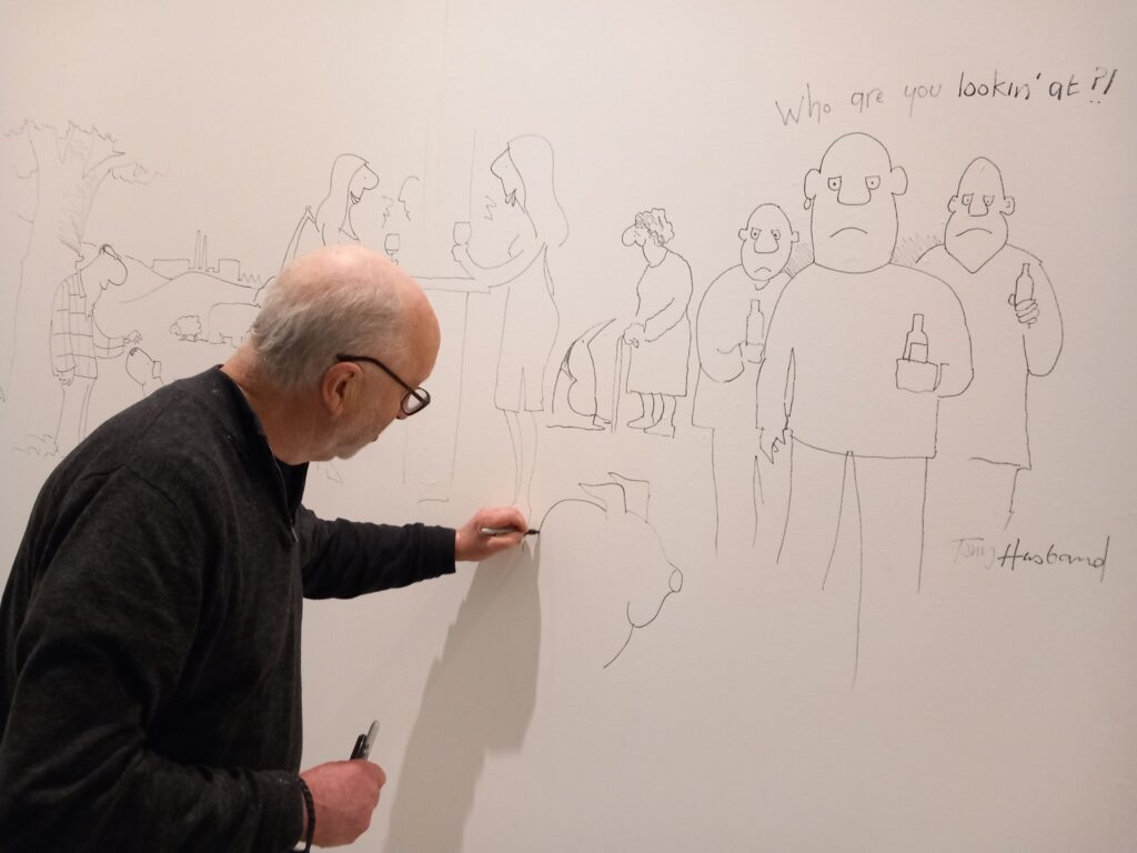 Tony Husband drawing on the walls of Gallery Oldham earlier this year. "He was a great friend to Gallery Oldham and will be much missed," the Gallery said on Twitter. Photo: Gallery Oldham
