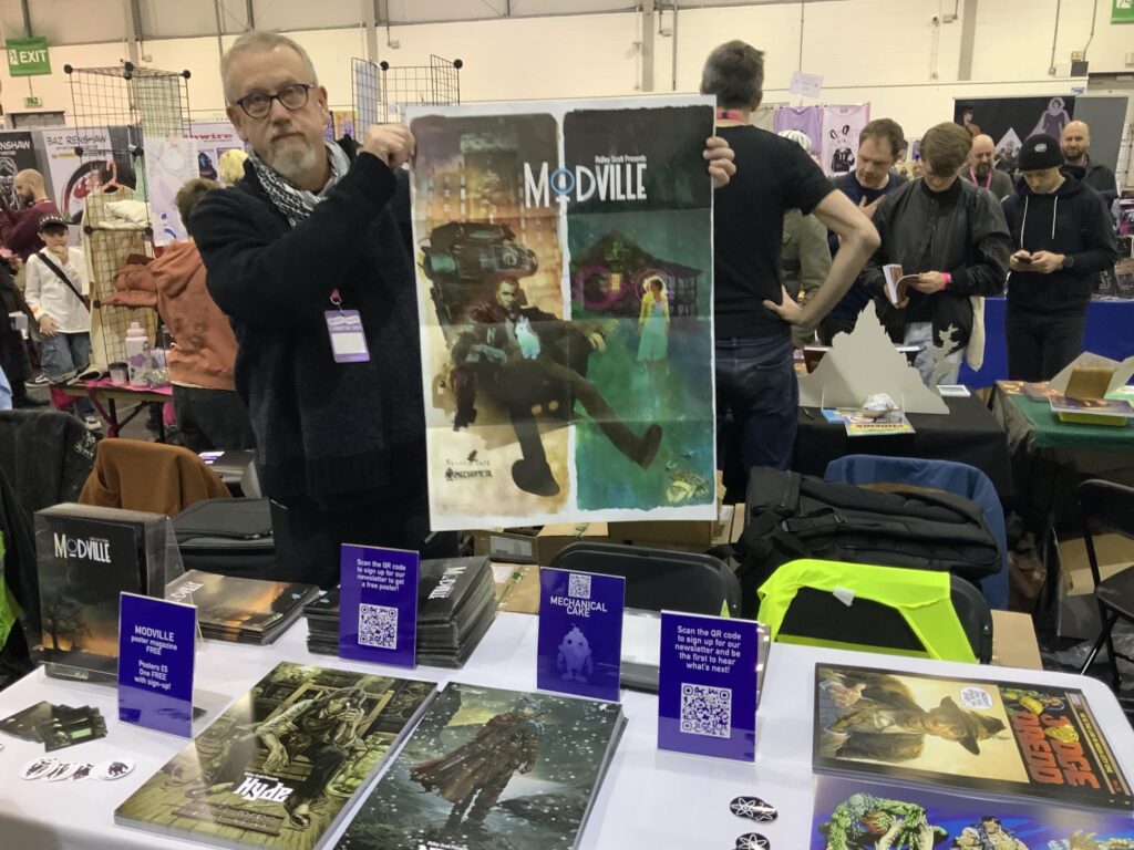 Publisher Dave Elliott with a poster for Modville, with art by Bill Sienkiewicz, a giveaway at Thought Bubble. More about this project here - https://downthetubes.net/ridley-scott-enters-graphic-novel-space/
