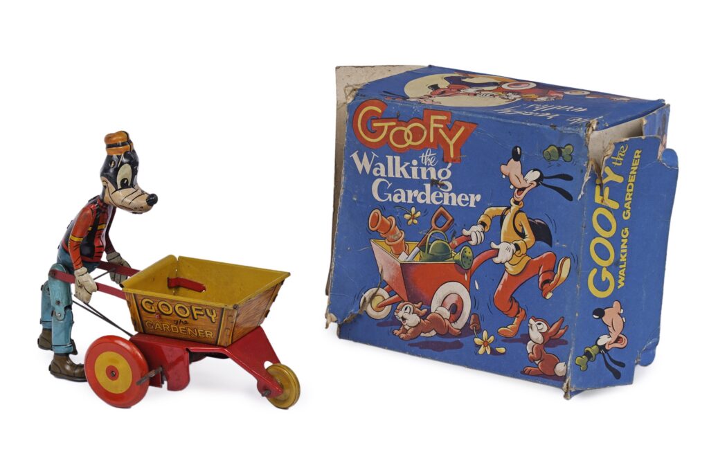 A Marx Toys 'Goofy The Walking Gardener' clockwork tinplate toy, modelled holding a wheelbarrow, 22 x 20cms high, with original box