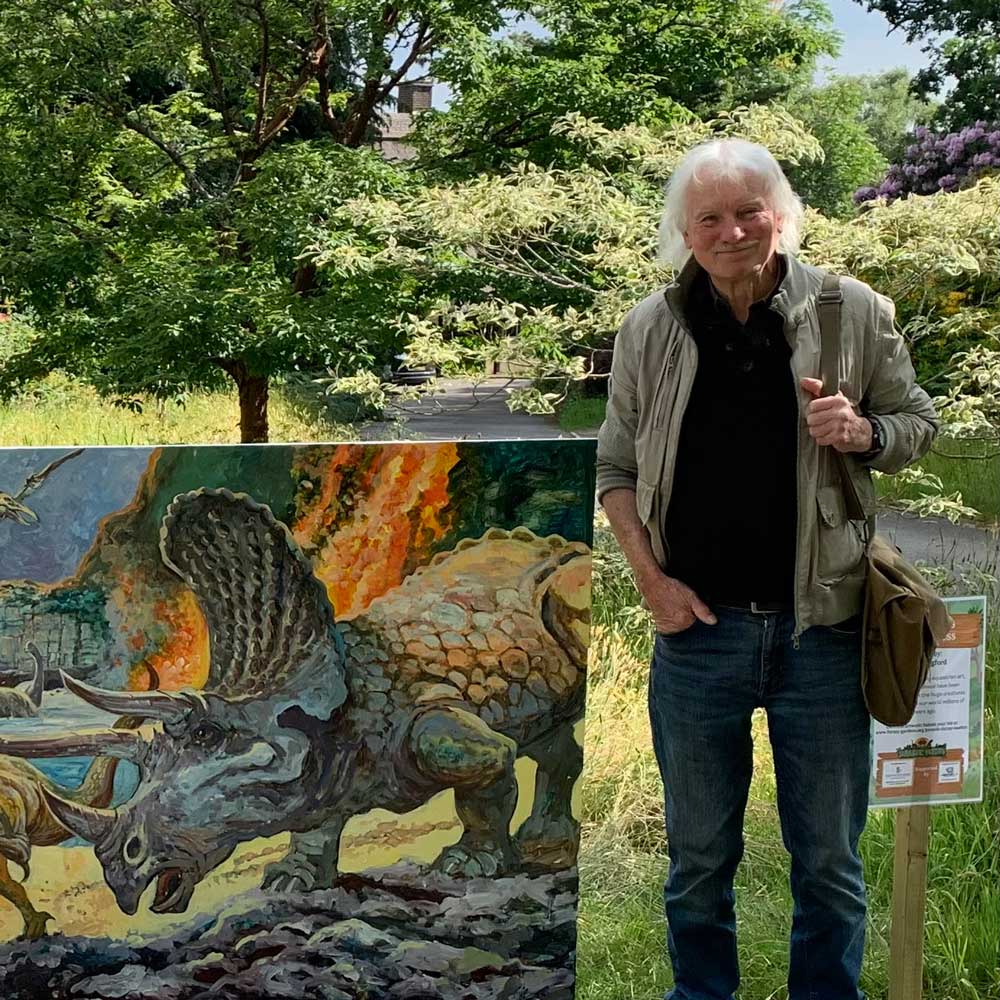 Alan Langford in Furzey Gardens, 2025, with his dinosaur art for the "Jurassic Furzey" project