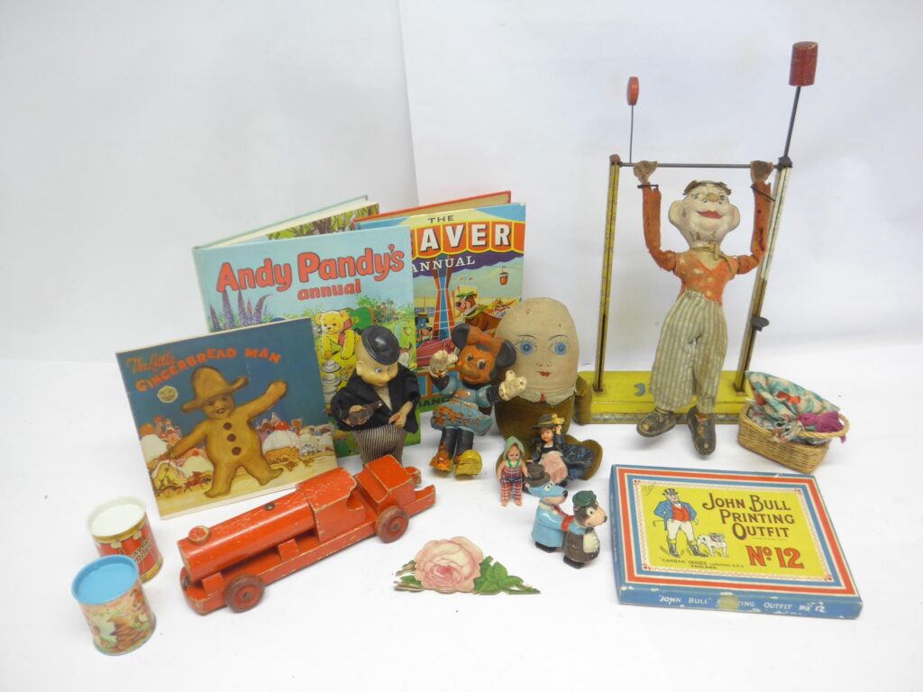 A collection of vintage toys and annuals including Arnold tinplate acrobatic clown (losses to face and clothing), clockwork bartender, wooden pull-along locomotive, Bendy Minnie Mouse (heavily fatigued), Humpty Dumpty soft toy, John Bull Printing Outfit, Marx plastic Yogi Bear and Huckleberry Hound walking toy, miniature dolls, etc.