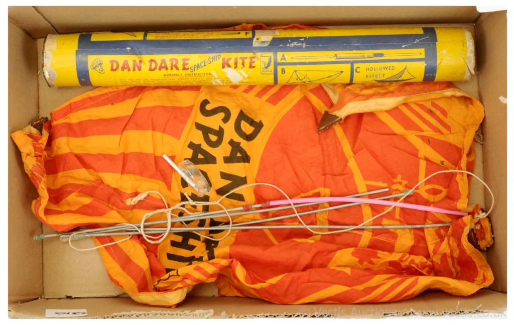This "Dan Dare Space Ship Kite" was sold for £110 by Vectis in 2022. It was described as "a very rare early 1950s toy kite comprising a yellow/orange cloth kite marked "Dan Dare Space Ship" with a quantity of aluminium rods and string - an unusual toy".