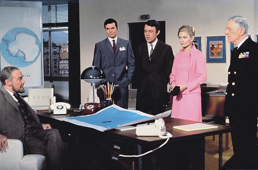 A still promoting The Champions episode “The Dark Island”. Tremayne (Anthony Nicolls) briefs Craig Stirling (Stuart Damon), Richard Barrett (William Gaunt) and Sharron Macready (Alexandra Bested), watched by the Admiral (Alan Gifford)| Via Jaz Wiseman