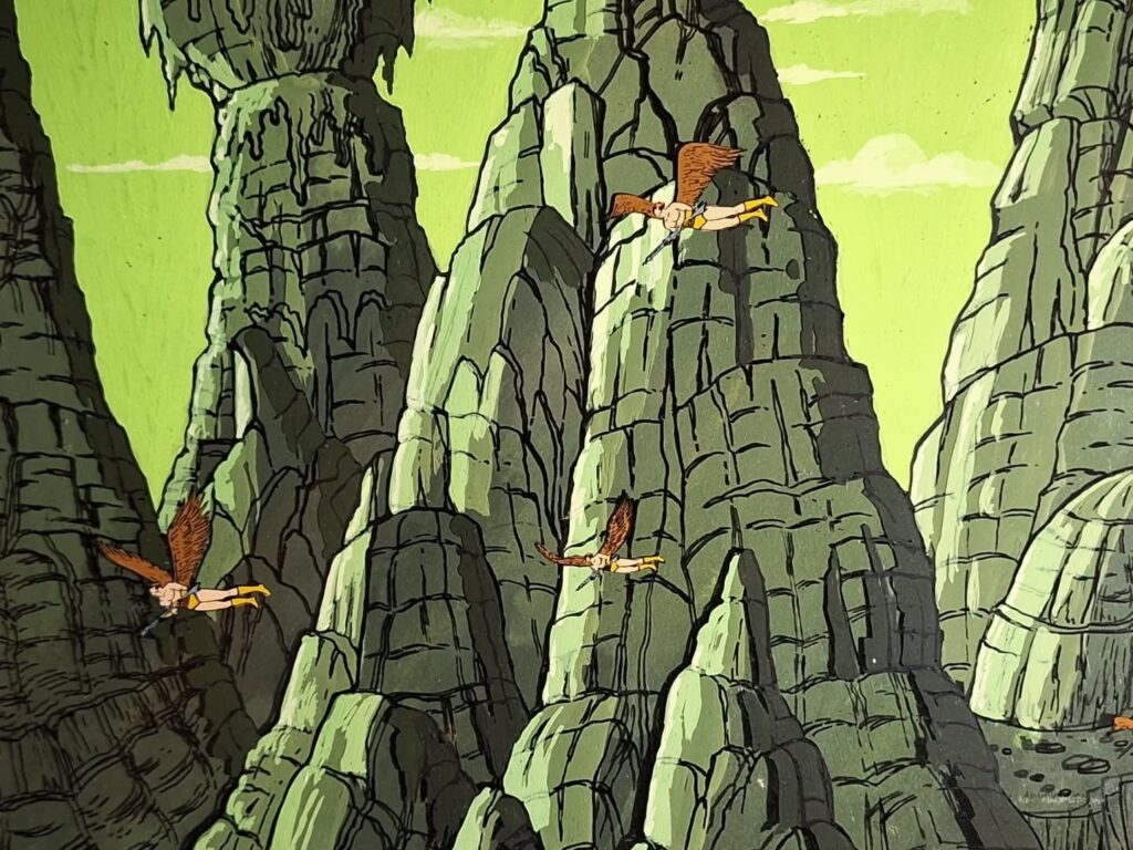 A Filmation animation cel of some Hawkmen flying past a mountain range on the planet Mongo! “I had no idea that Filmation would build up their background artwork as a series of acetate layers in addition to placing the acetate cels over them,” says Neil Cole