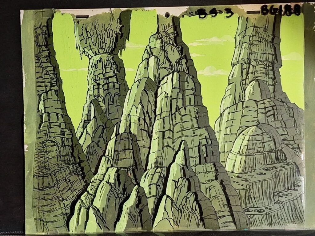 A Filmation animation cel of some Hawkmen flying past a mountain range on the planet Mongo! “I had no idea that Filmation would build up their background artwork as a series of acetate layers in addition to placing the acetate cels over them,” says Neil Cole