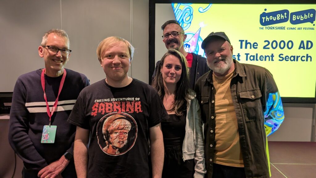 2025 Thought Bubble Talent Search art competition winner Philip Read with judges Steve Yeowell (left), DaNi (second from right), Jock (right) and host Molch-R | Photo: 2000AD