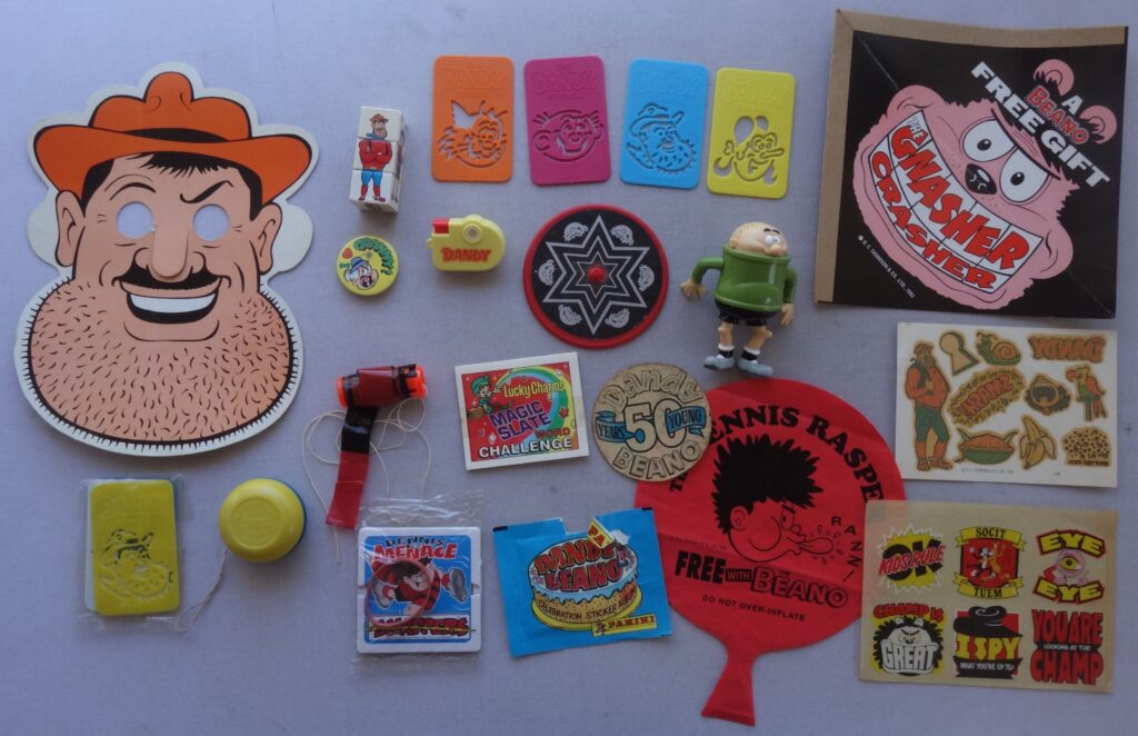 Seven badges given away as free gifts in The Dandy comic in the 1990s. The Cuddles and Dimples badges, Korky badge and the two non-round Desperate Dan badges have yellowed. As a guide, the large round badge measures 55mm in diameter