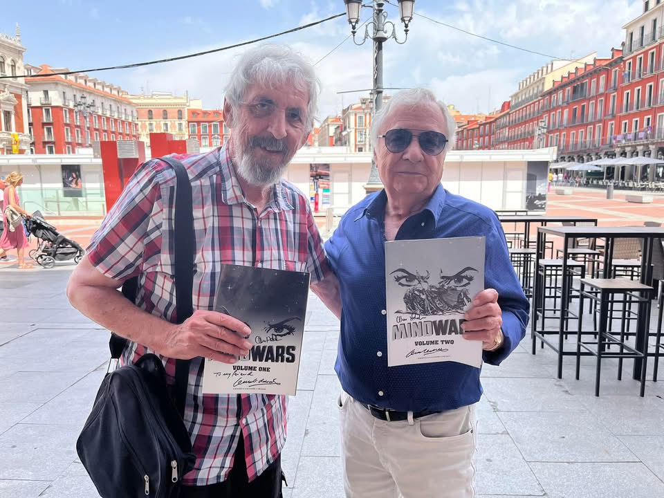Alan Hebden and Jesus Redondo in 2022, with copies of the Mind Wars reprint included in two 2019 issues of Judge Dredd Megazine. Photo via Alan Hebden 