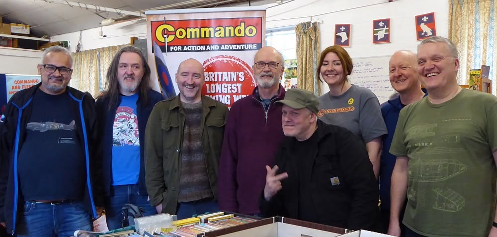 A Commando Comics raiding party at Commando Swap Meet 10 in Glasgow in 2023. Left to right: Suresh Ramasubramanian (writer), Graeme Neil Reid (cover artist), Keith Burns Aviation Art (cover artist), Calum Laird (former editor and current writer), Gordon Tait (editor), Kate McAuliffe (editor and writer), Colin Maxwell (writer), and Stephen Hume (writer and swap meet organiser). Photo: Jeremy Briggs