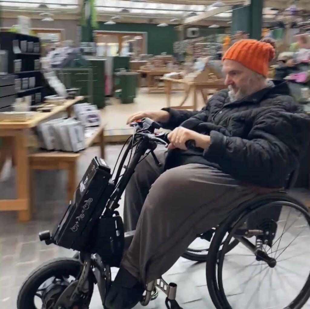 Al Davison testing out an enhancement to his wheelchair… can you help him secure it?