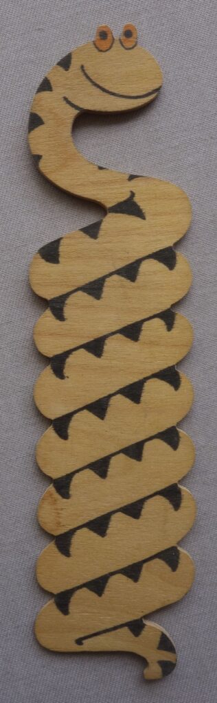 Phil-Comics has been consigned this interesting and unusual balsa wood style item, which appears to be Sid's Snake, from Whizzer and Chips, but it wasn't given away as a free gift with the comic, although there is a possibility it was gifted as a competition prize. For example, in the issue of Whizzer and Chips, cover dated 19th October 1974, there was a competition that gave away £1 per week for a year as a first prize, with 250 other prizes of Bumper Joke Boxes and 500 Whizzer and Chips baseball caps. There's a picture of the joke box, but we don't know if it was literally the box, or a box with various joke type items (we suspect the latter), so there's a chance it came as one of the items in here, but Phil Shrimptin admits he is merely speculating here. The jury is out as to where this originated. The auction house has certainly not seen another one on the market. An alternative solution is that it's just a one-off home made item, albeit one of very good quality, with beautifully smooth, rounded edges down the length of the tail. Nice ink print, too. It measures just under 7 inches in length and 1.5 inches in width.
