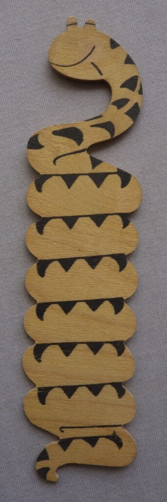 Phil-Comics has been consigned this interesting and unusual balsa wood style item, which appears to be Sid's Snake, from Whizzer and Chips, but it wasn't given away as a free gift with the comic, although there is a possibility it was gifted as a competition prize. For example, in the issue of Whizzer and Chips, cover dated 19th October 1974, there was a competition that gave away £1 per week for a year as a first prize, with 250 other prizes of Bumper Joke Boxes and 500 Whizzer and Chips baseball caps. There's a picture of the joke box, but we don't know if it was literally the box, or a box with various joke type items (we suspect the latter), so there's a chance it came as one of the items in here, but Phil Shrimptin admits he is merely speculating here. The jury is out as to where this originated. The auction house has certainly not seen another one on the market. An alternative solution is that it's just a one-off home made item, albeit one of very good quality, with beautifully smooth, rounded edges down the length of the tail. Nice ink print, too. It measures just under 7 inches in length and 1.5 inches in width.